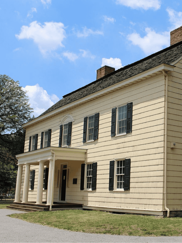 Historic Colonial House with Black Shutters and Classic Architecture.