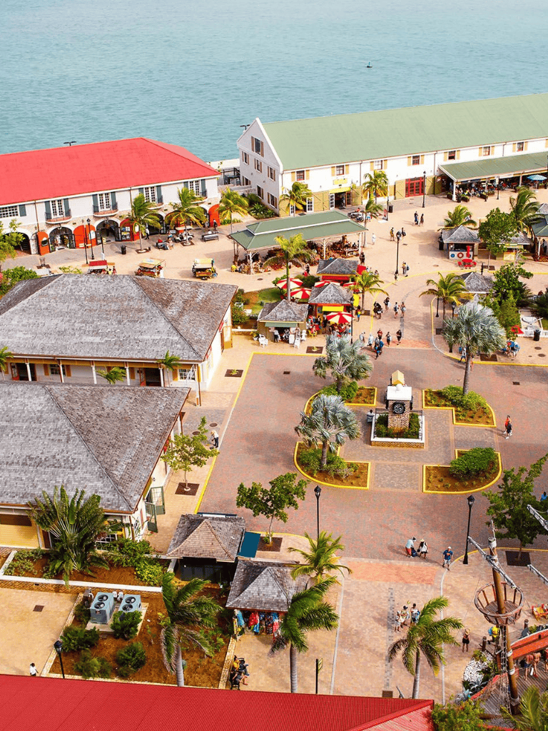 Vibrant coastal shopping and dining district with palm trees and waterfront views.