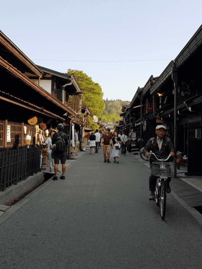 Charming traditional Japanese street with shops and pedestrians, popular for sightseeing and cultural exploration.