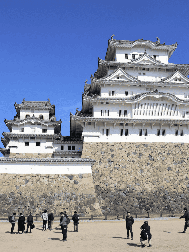 1. Beautiful Japanese castle with traditional architecture and stone foundation under a clear blue sky.
