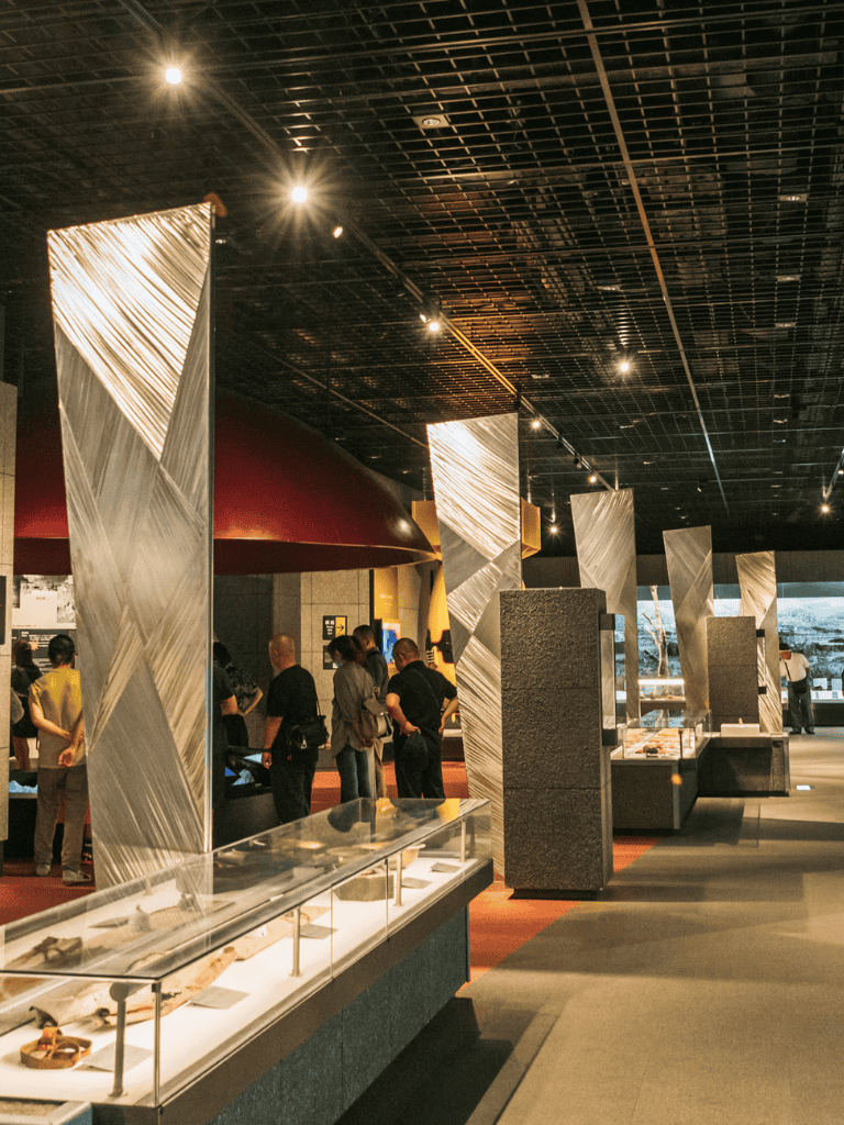 Museum exhibit with display cases and visitors, QuestForDirections interior focus.