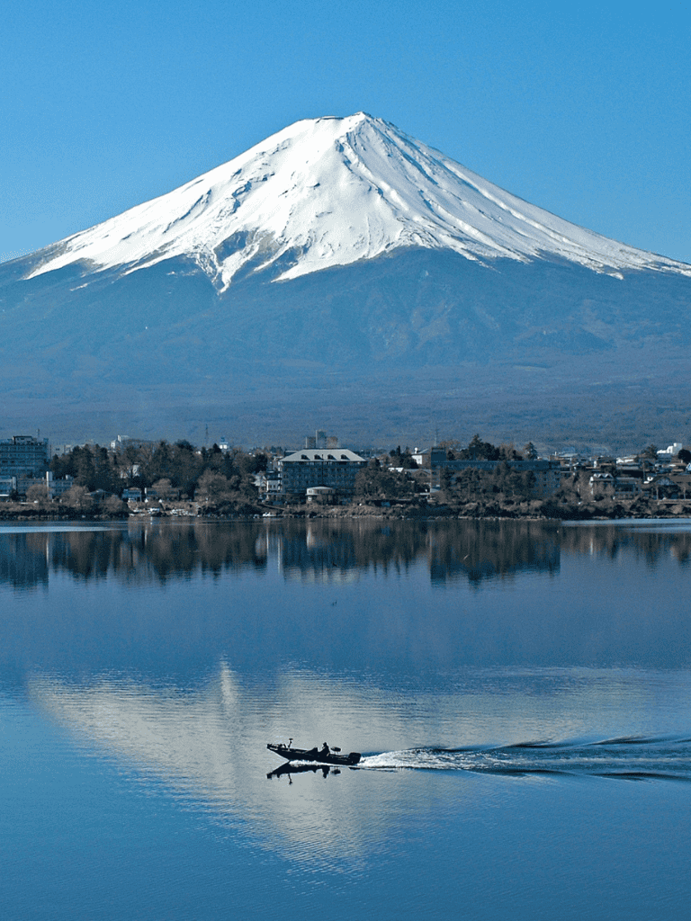 Snow-capped Mount Fuji with boat on lake and cityscape, Japan iconic landmark, travel, scenic landscape, QuestForDirections.