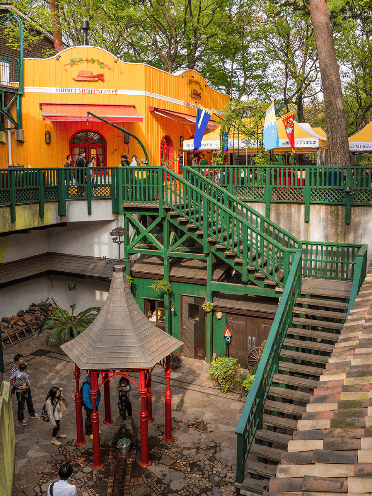 Vibrant themed area with colorful buildings, outdoor seating, and visitors at QuestForDirections.