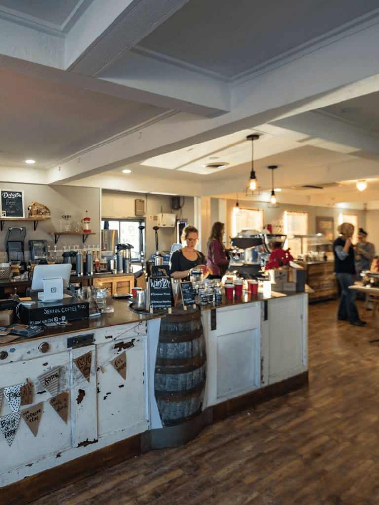 Cozy cafe interior at QuestForDirections coffee shop with barista serving customers.