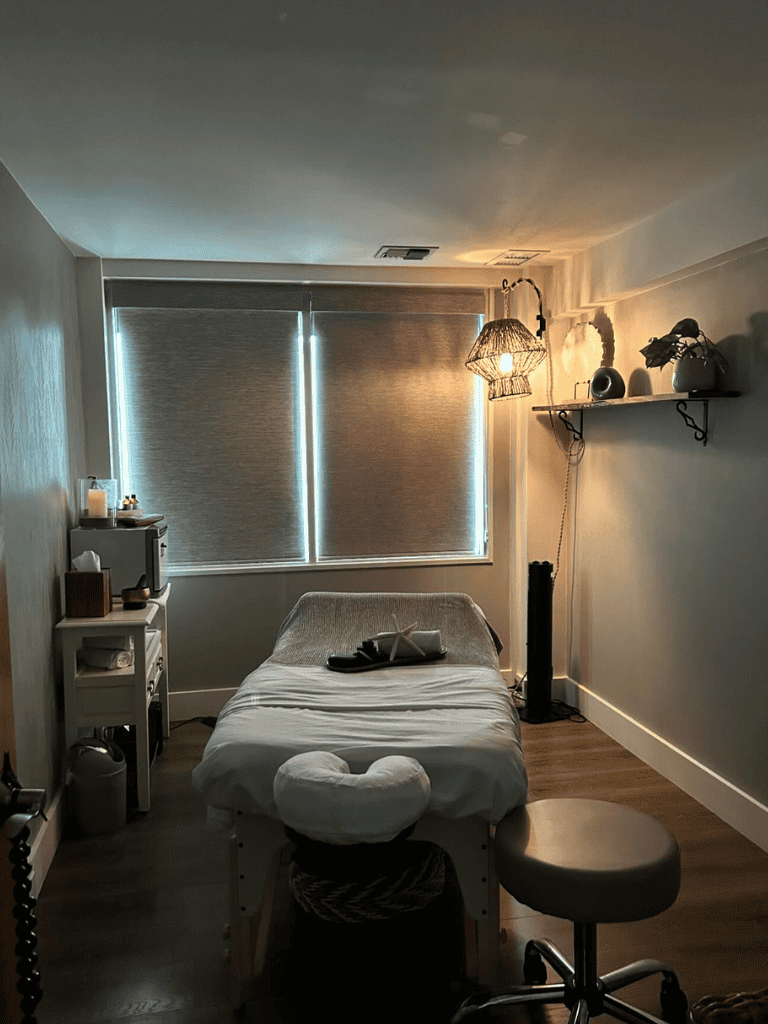 Calm massage therapy room with cozy treatment bed and ambient lighting for relaxation.