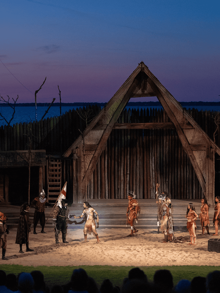 Ancient reenactment on stage with native costumes and historical setting at Quest For Directions.