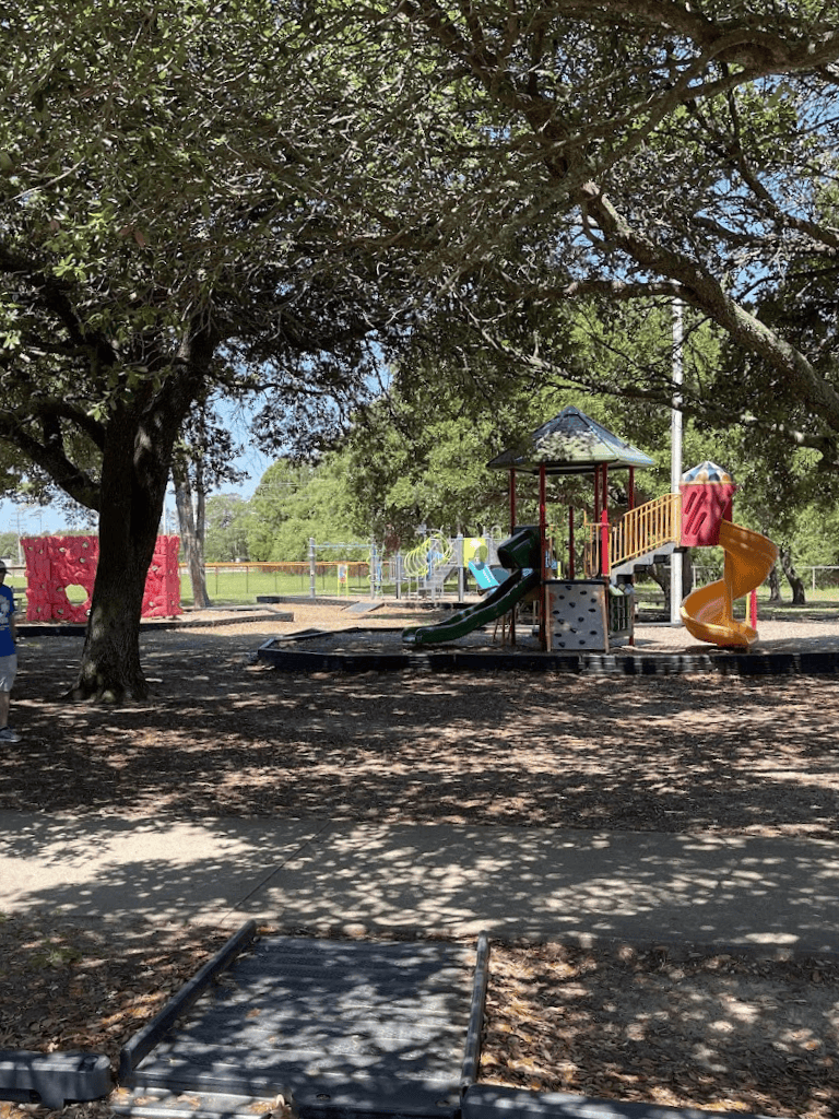 Colorful playground equipment in a shaded park area for kids’ outdoor fun and recreation.