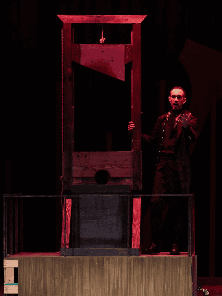 Mysterious wooden guillotine stage prop for theater or escape room setup.