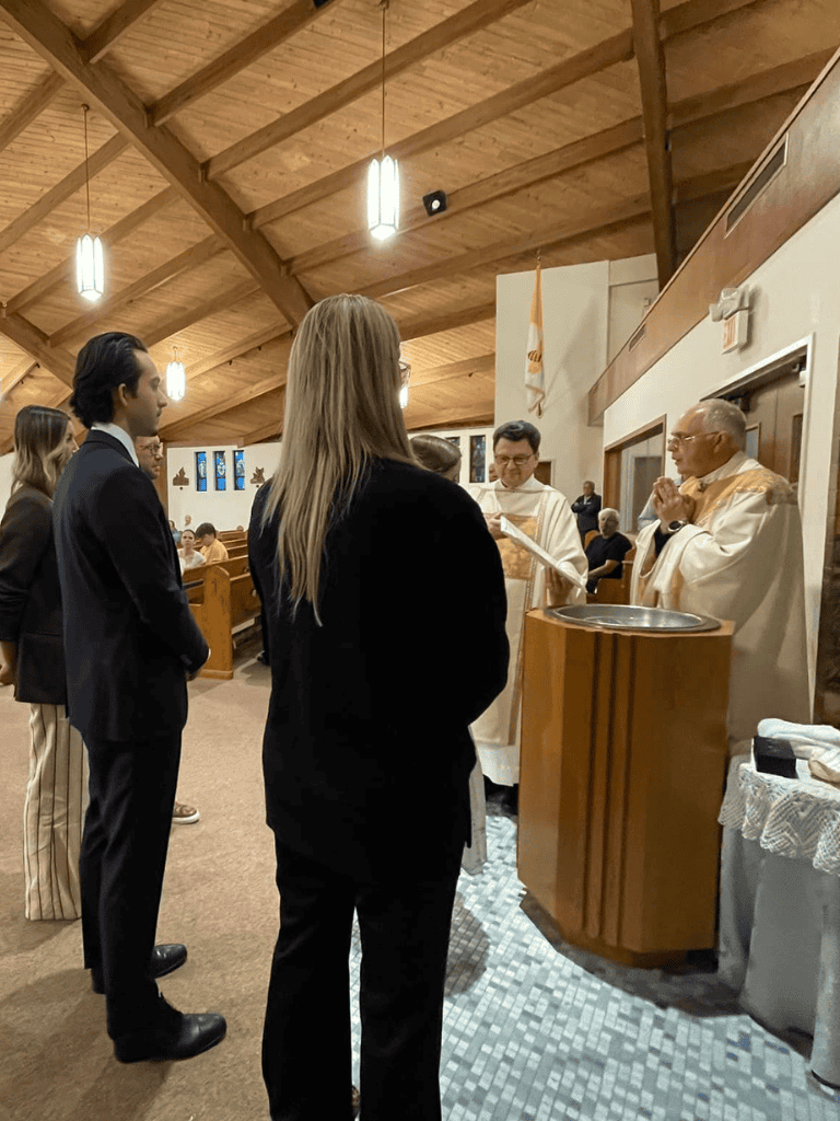 Altar call in church with people praying and clergy conducting service in a chapel setting.