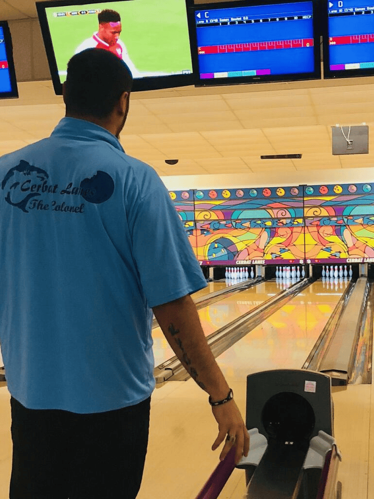Bright bowling alley scene with a player preparing to bowl and colorful graphics on the back wall.