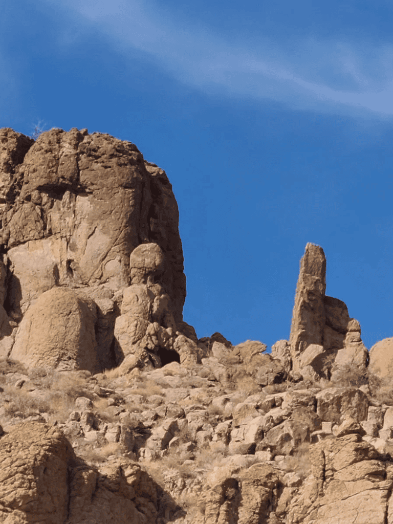 Rustic desert rock formations with a clear blue sky, emphasizing adventure and exploration.