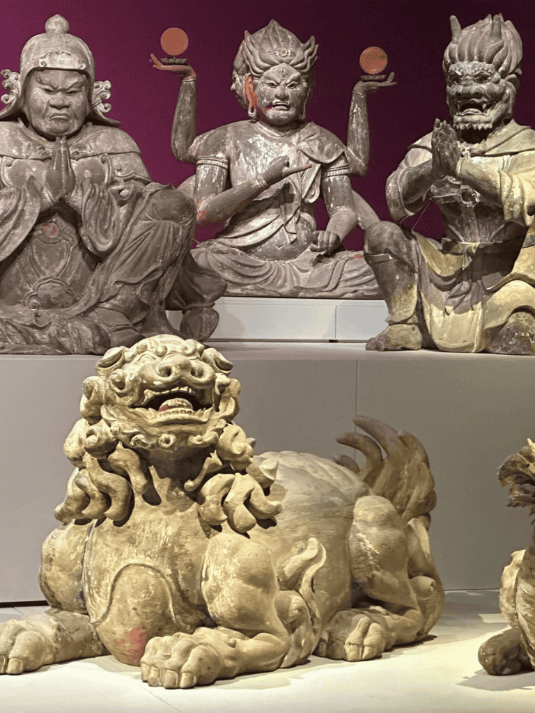 Ancient Asian mythological statues representing guardians and deities, highlighting cultural art and religious symbolism.