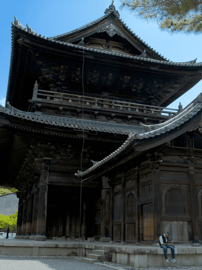 Ancient Japanese temple with traditional wooden architecture and curved tiled roof.