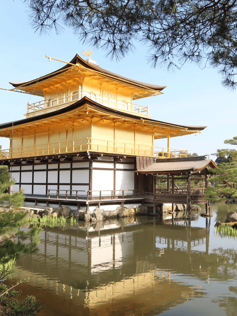 Golden Japanese pagoda by tranquil pond with lush greenery at QuestForDirections.