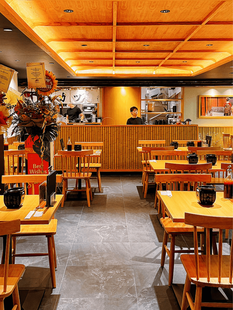 Cozy Japanese restaurant interior with wooden furniture and warm lighting for authentic dining experience.