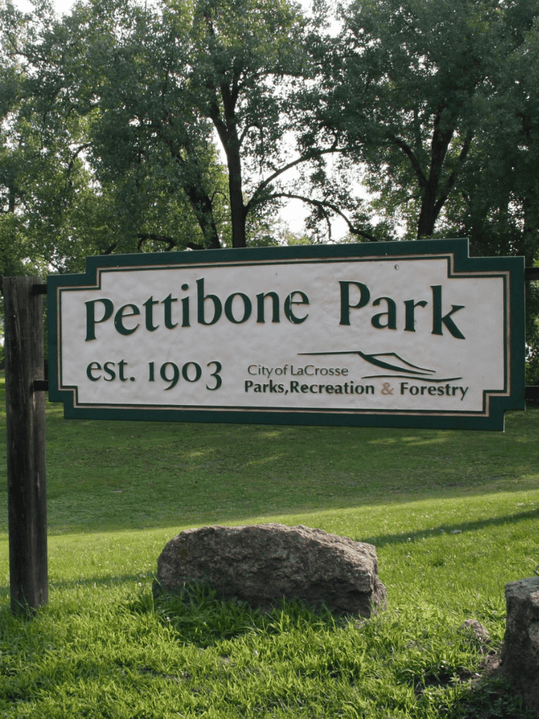 Pettibone Park sign in La Crosse, Wisconsin, established 1903, featuring lush greenery and mature trees.