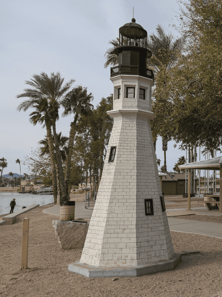 Vintage lighthouse sculpture at a scenic coastal park, perfect for ocean navigation and maritime safety.
