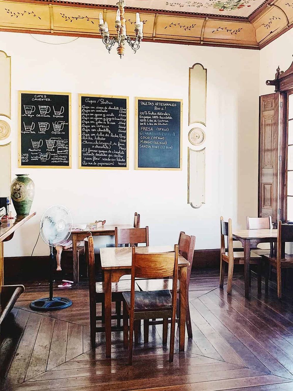Traditional Spanish cafe interior showcasing daily menu boards, wooden furniture, and cozy ambiance.