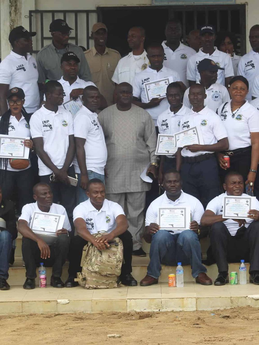 1. Group of diverse people holding certificates during a community achievement event in Africa.