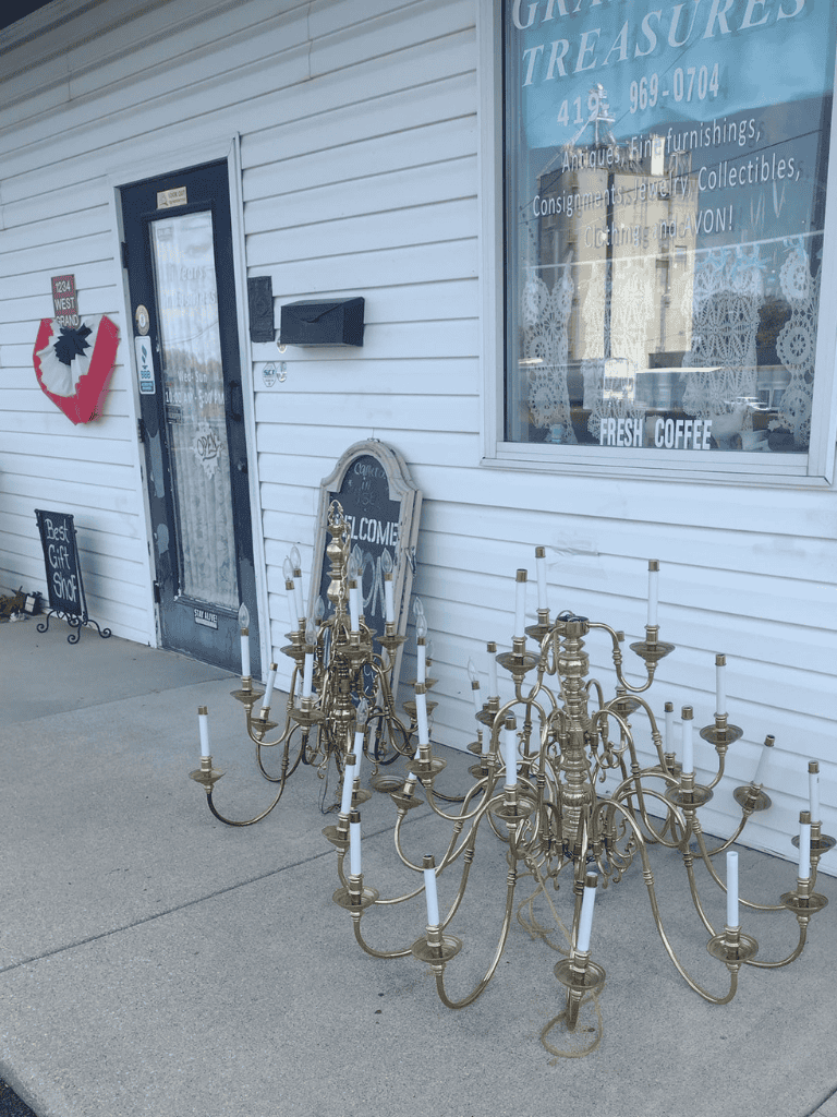 Old brass chandeliers outside antique shop, vintage home decor, lighting fixtures, collectibles, furniture, jewelry, and more.