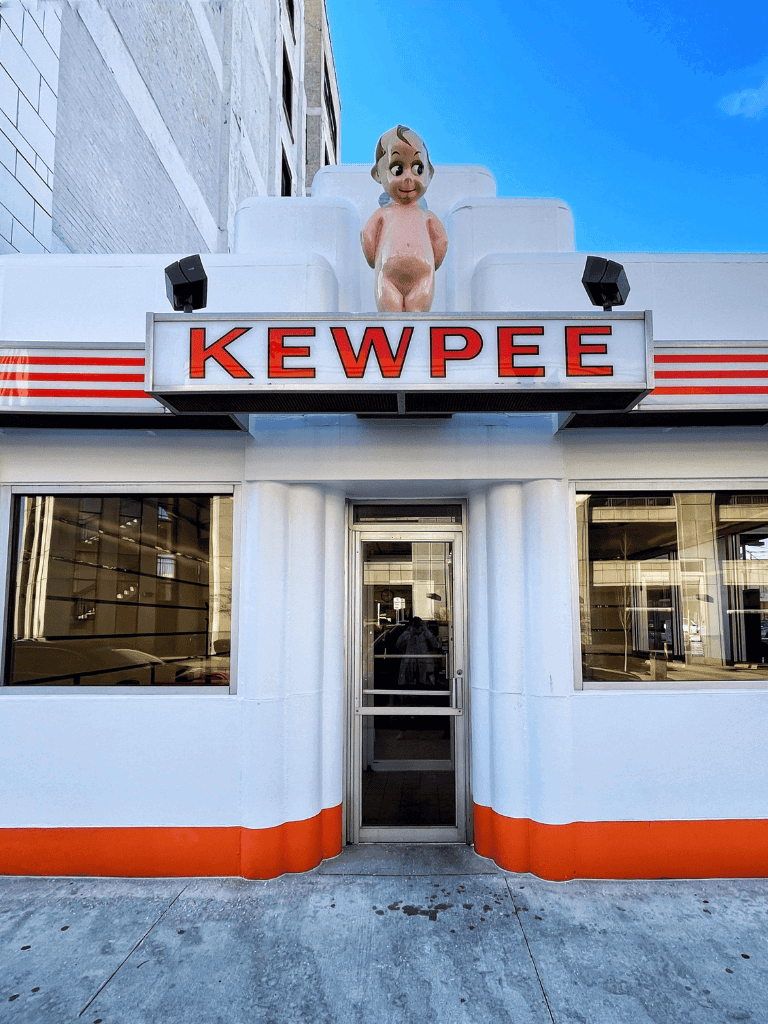 Retro fast food restaurant Kewpee with vintage character signage, bright exterior, and classic Art Deco style.