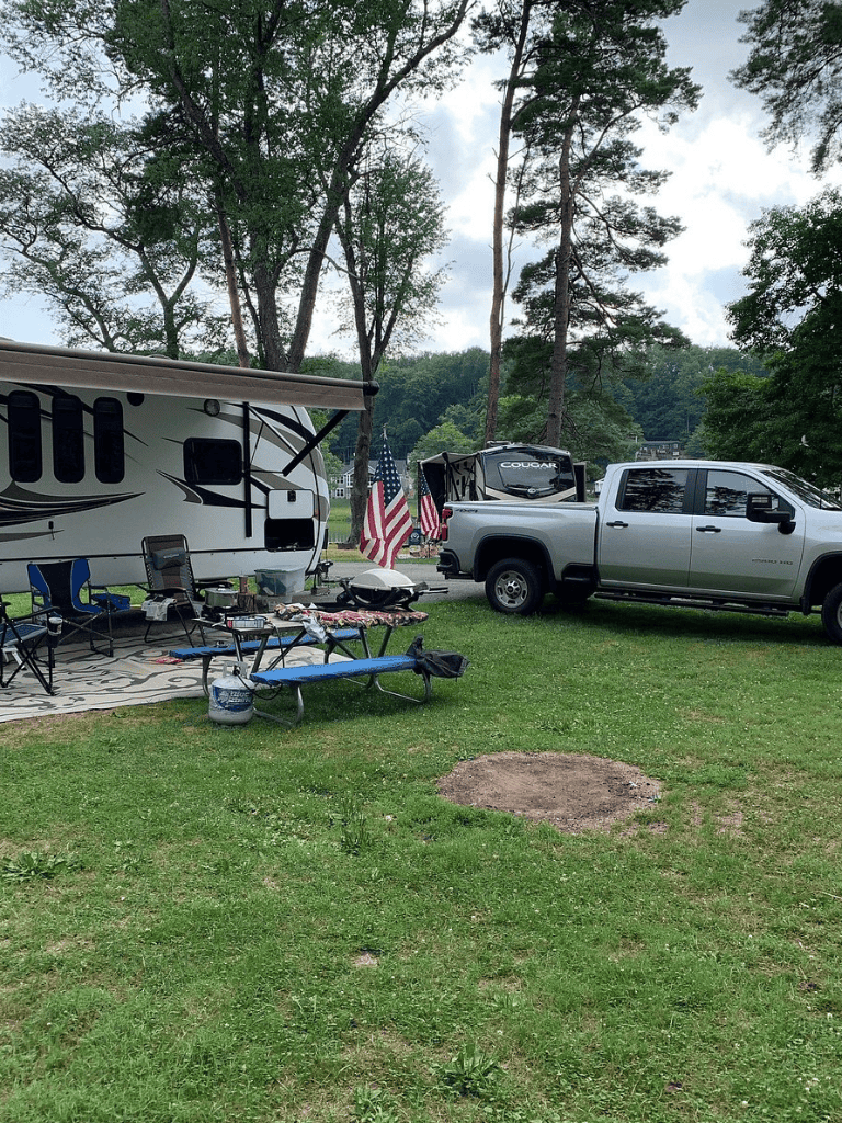 Americana flags at a campground with RV and outdoor seating, highlighting travel and outdoor adventure.