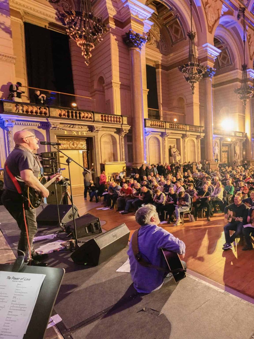 Vibrant concert scene inside historic hall with audience and musicians, capturing cultural events and live performances.