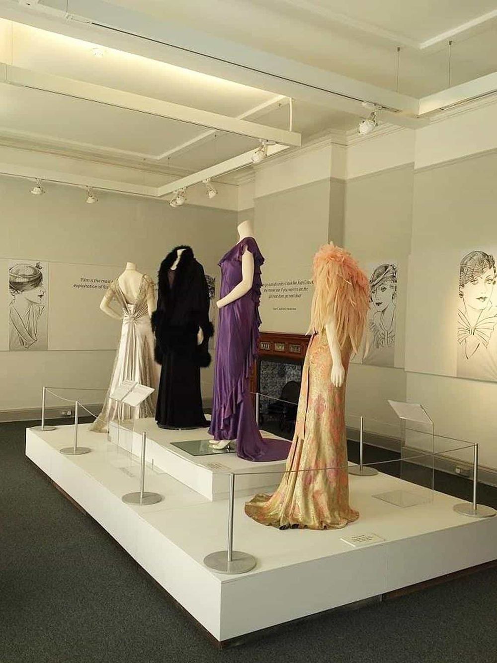 Elegant designer dresses on mannequins at a fashion exhibit.