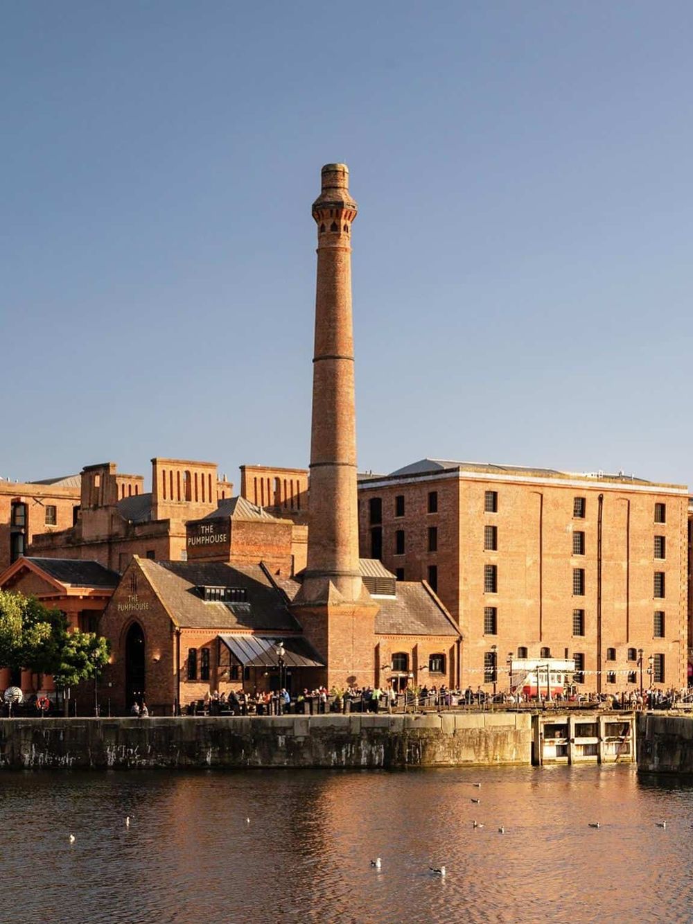 Industrial historic building with chimney by water, part of QuestForDirections focus on local landmarks and navigation.