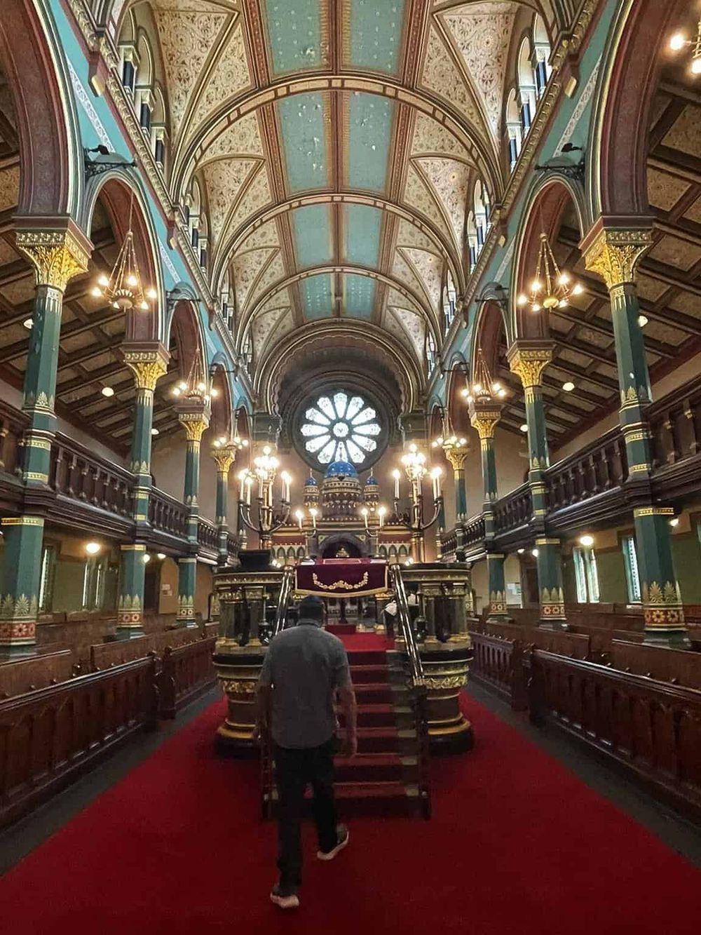 Intricate cathedral interior with stained glass, ornate arches, and grand staircase in historic architecture.
