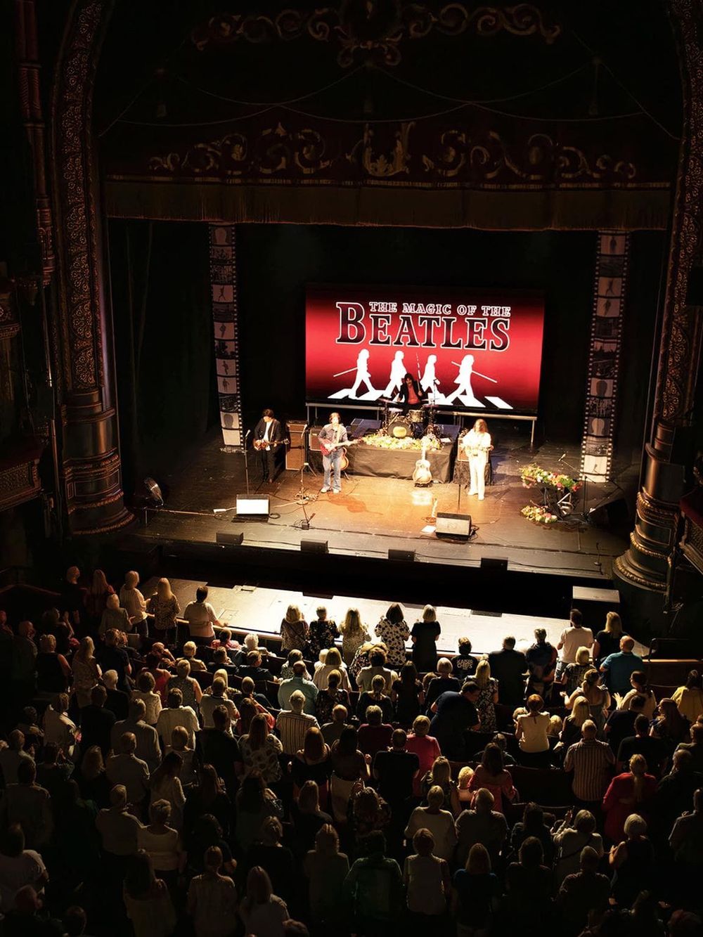Live Beatles tribute concert at a historic theater showcasing classic music performances.
