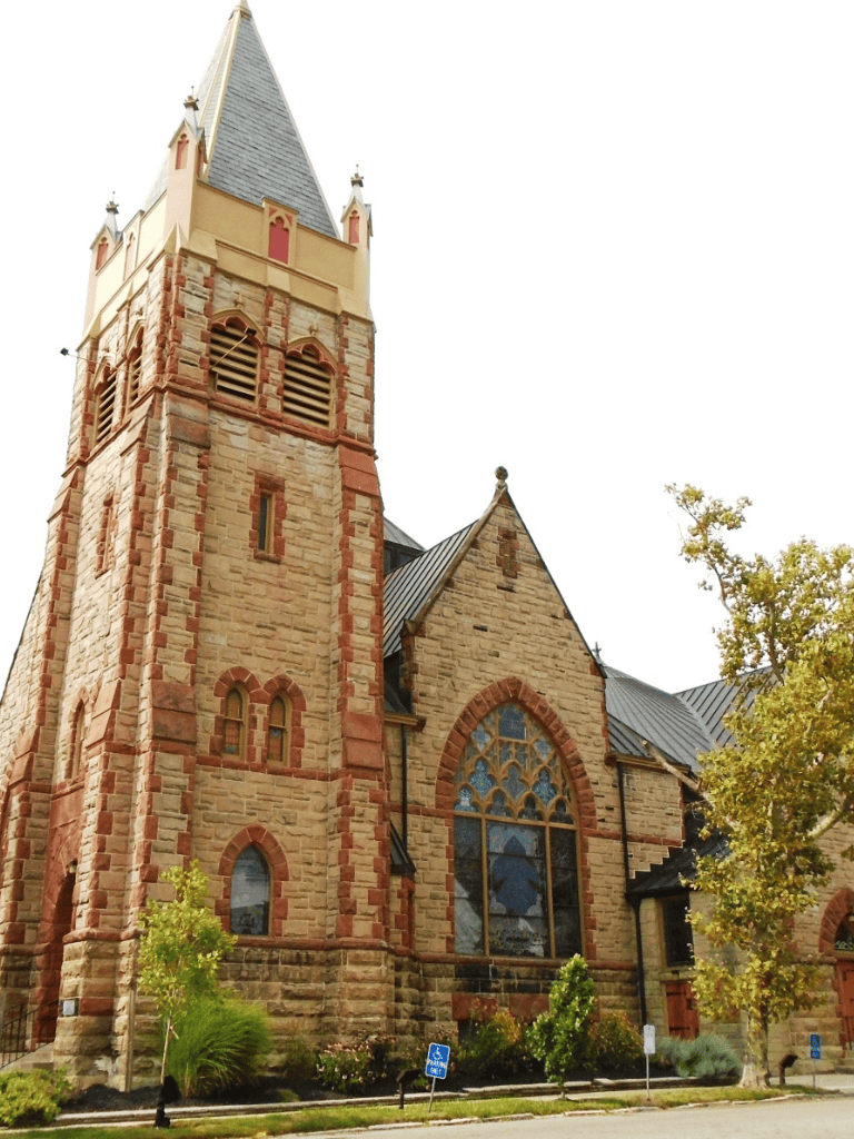 Astonishing historic church with Gothic architecture, stone facade, and stained glass windows, located in a charming city center.