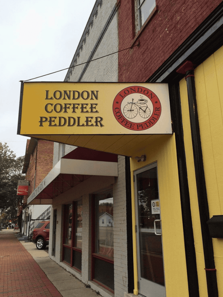 London coffee peddler store sign, cozy café in downtown with bicycle logo, inviting ambiance for coffee lovers.