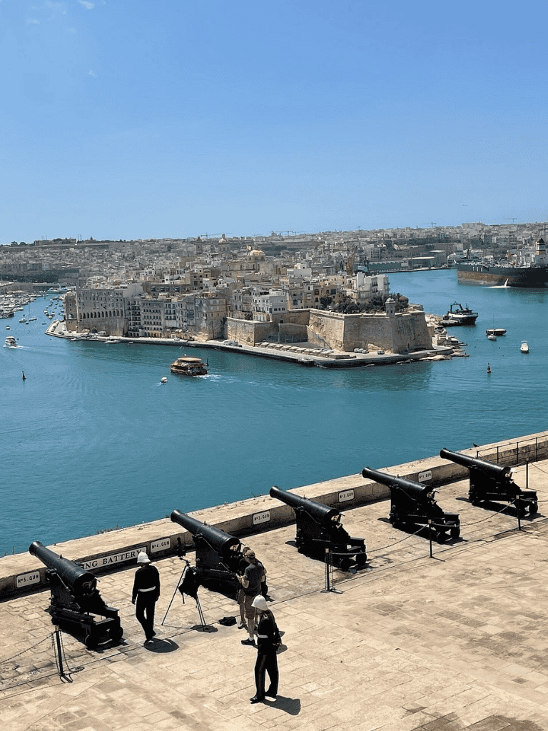 Historic fortifications along the Mediterranean waterfront in Valletta, Malta with cannons and scenic harbor views.