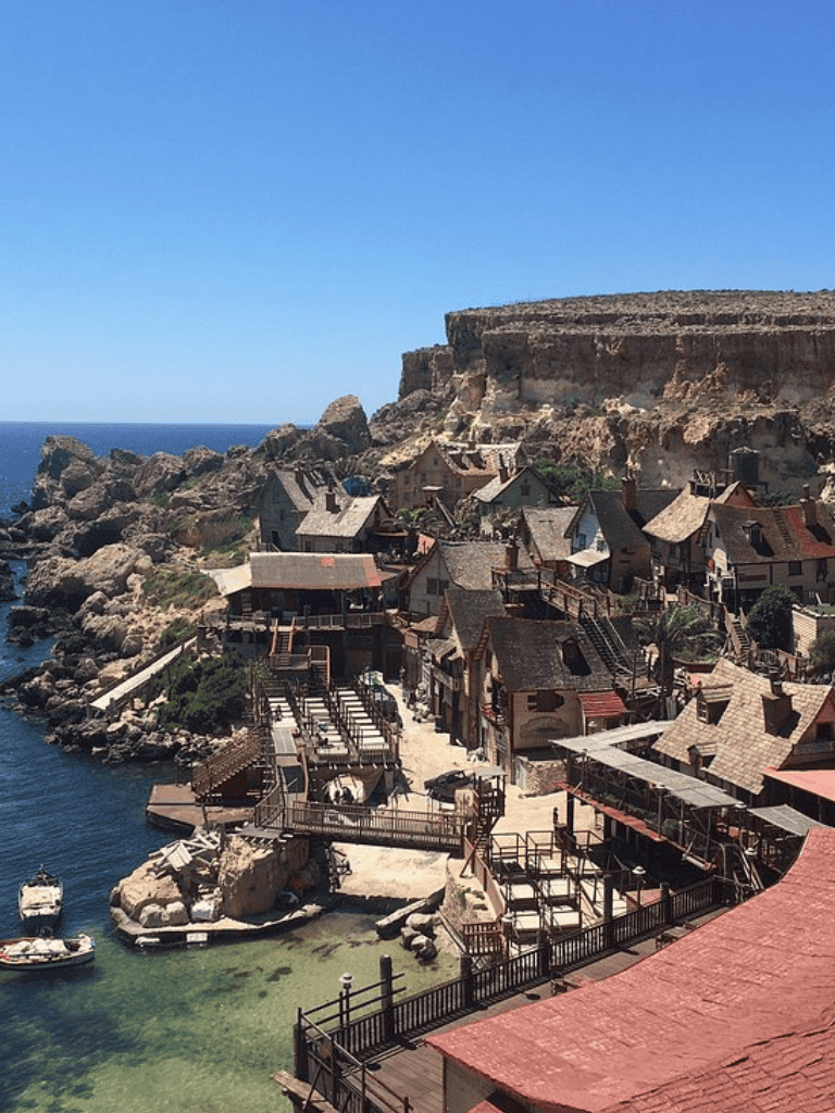 Cliffside coastal village with rustic houses and clear waters, ideal for scenic travel and waterfront exploration.