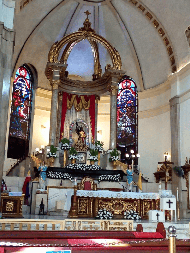 Brightly lit church altar with religious statues, stained glass windows, and intricate gold decor, highlighting spiritual and sacred architecture.