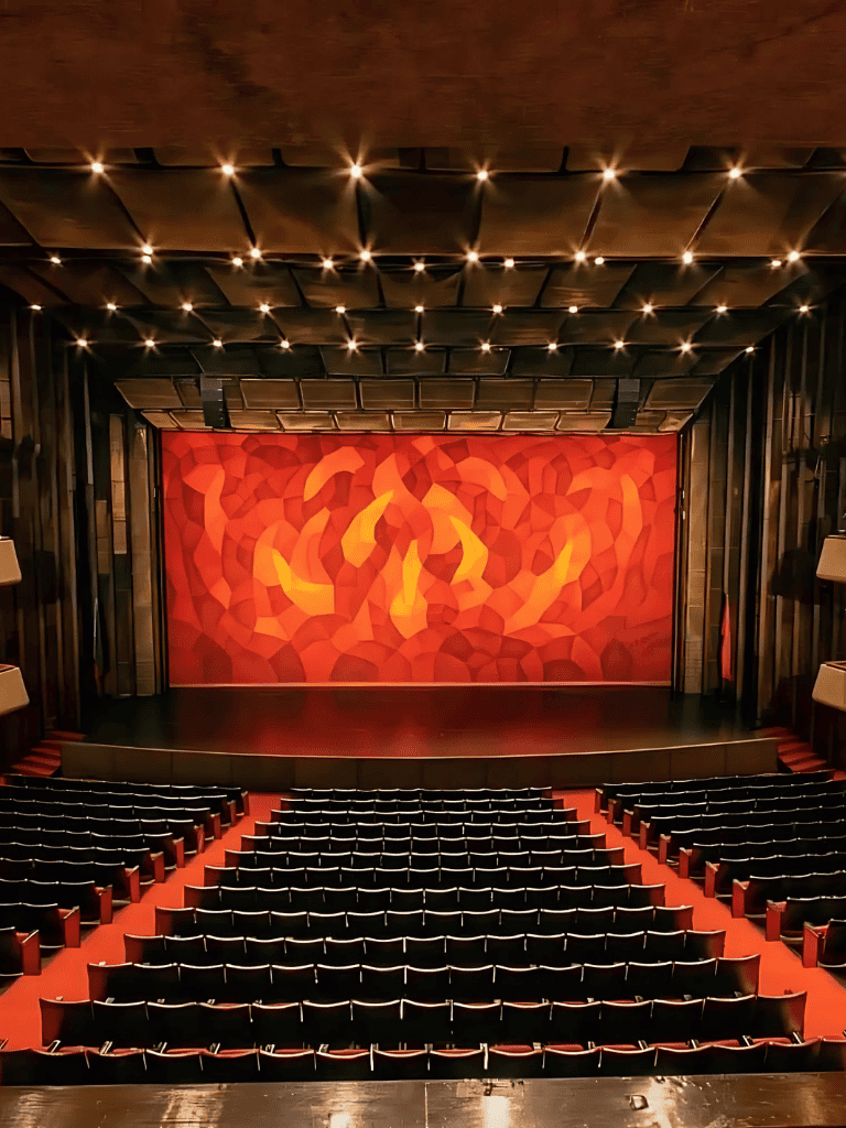 Vibrant theater stage with fiery red and orange backdrop, perfect for live performances and events.