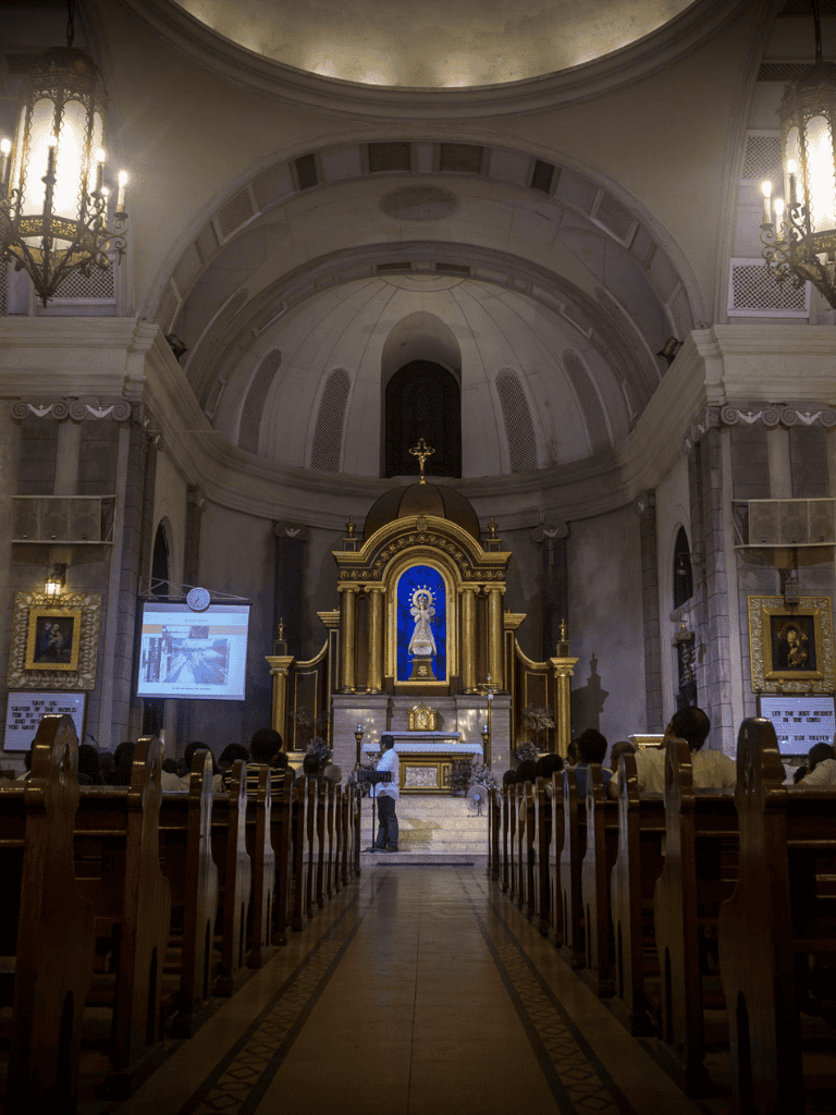 1. Interior of a Catholic church with altar and pews, religious architecture and stained glass windows.