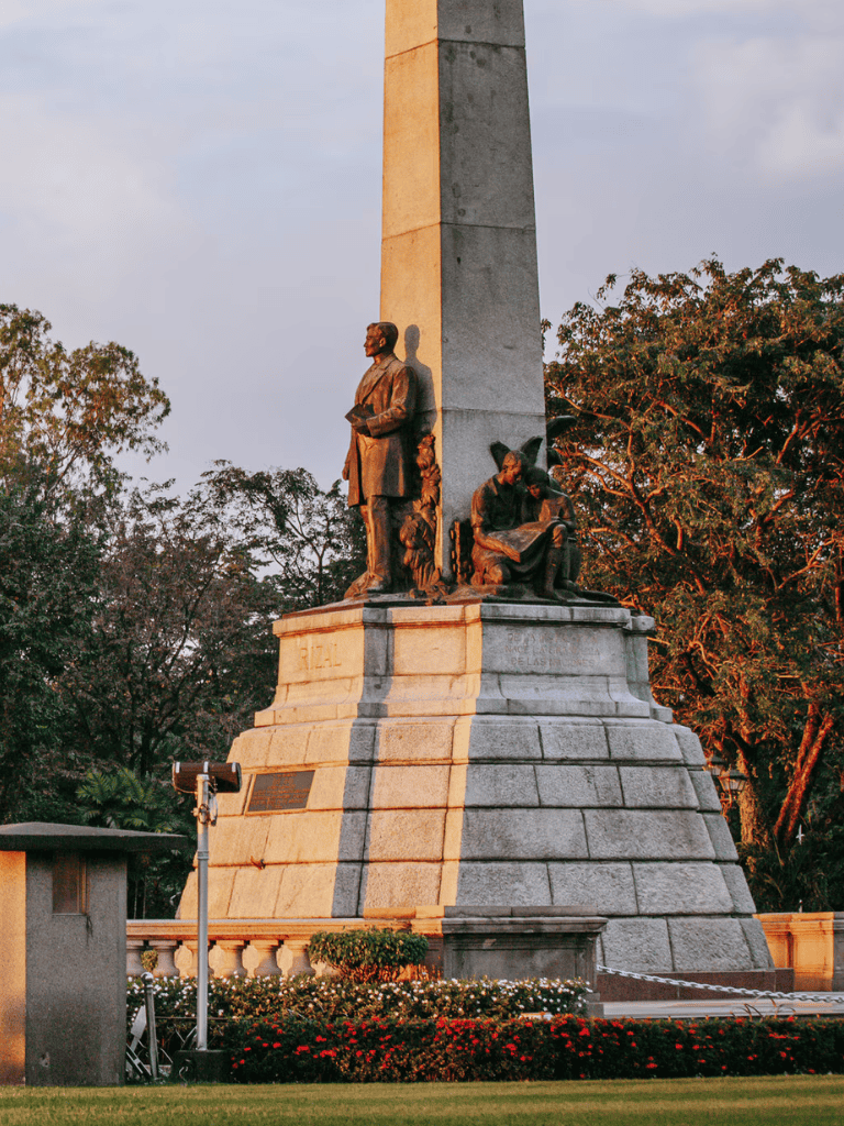 1. Historic monument with statues and obelisk in a park setting, celebrating heritage.
