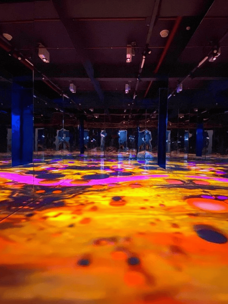Colorful interactive mirror and projection art exhibit with vibrant reflections and immersive visual effects.