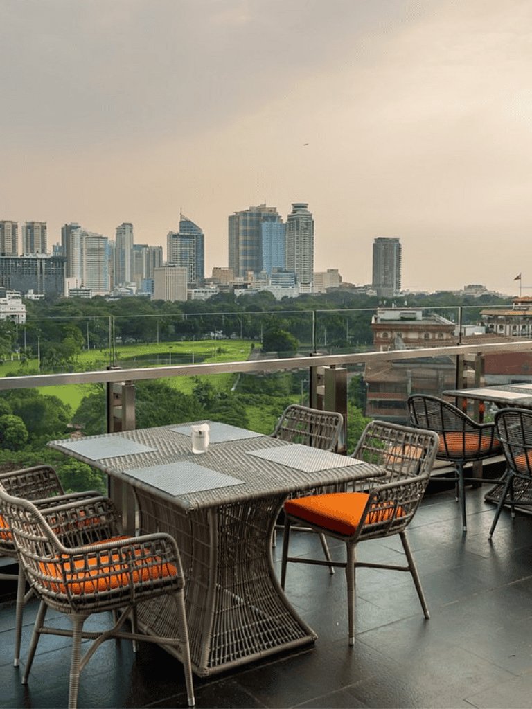 1. Modern city skyline view from rooftop restaurant with outdoor dining area.