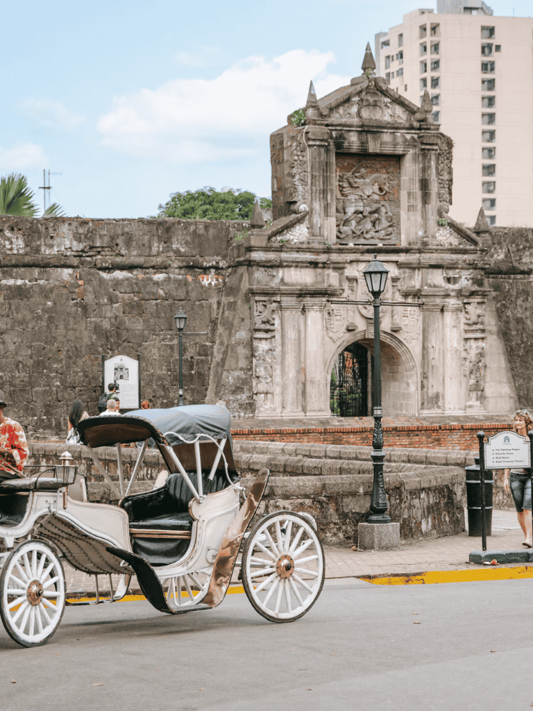 Horse-drawn carriage in front of historic stone archway, colonial architecture, tourist attraction, QuestForDirections.