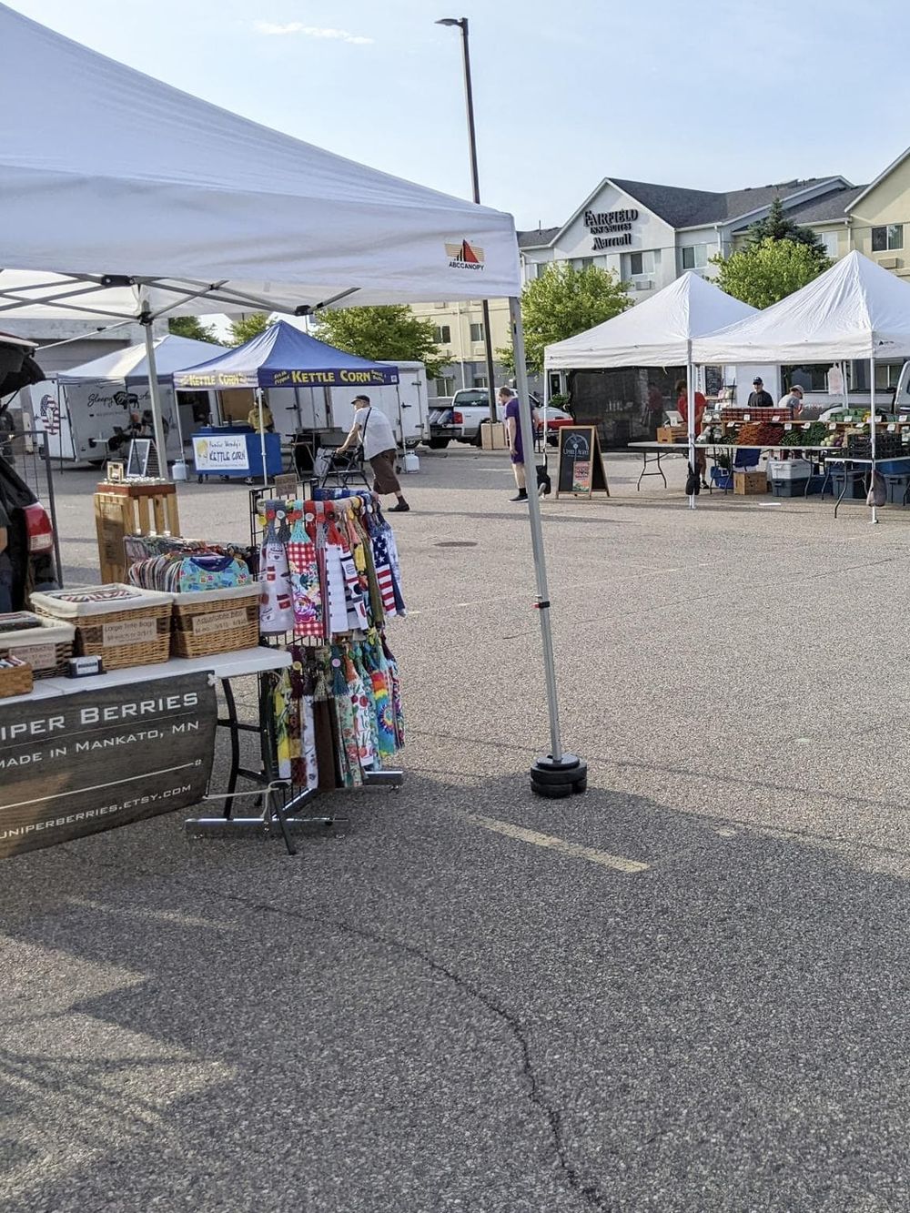 Colorful outdoor farmers market with white tents and local vendors, vibrant community event for fresh produce and handmade crafts.