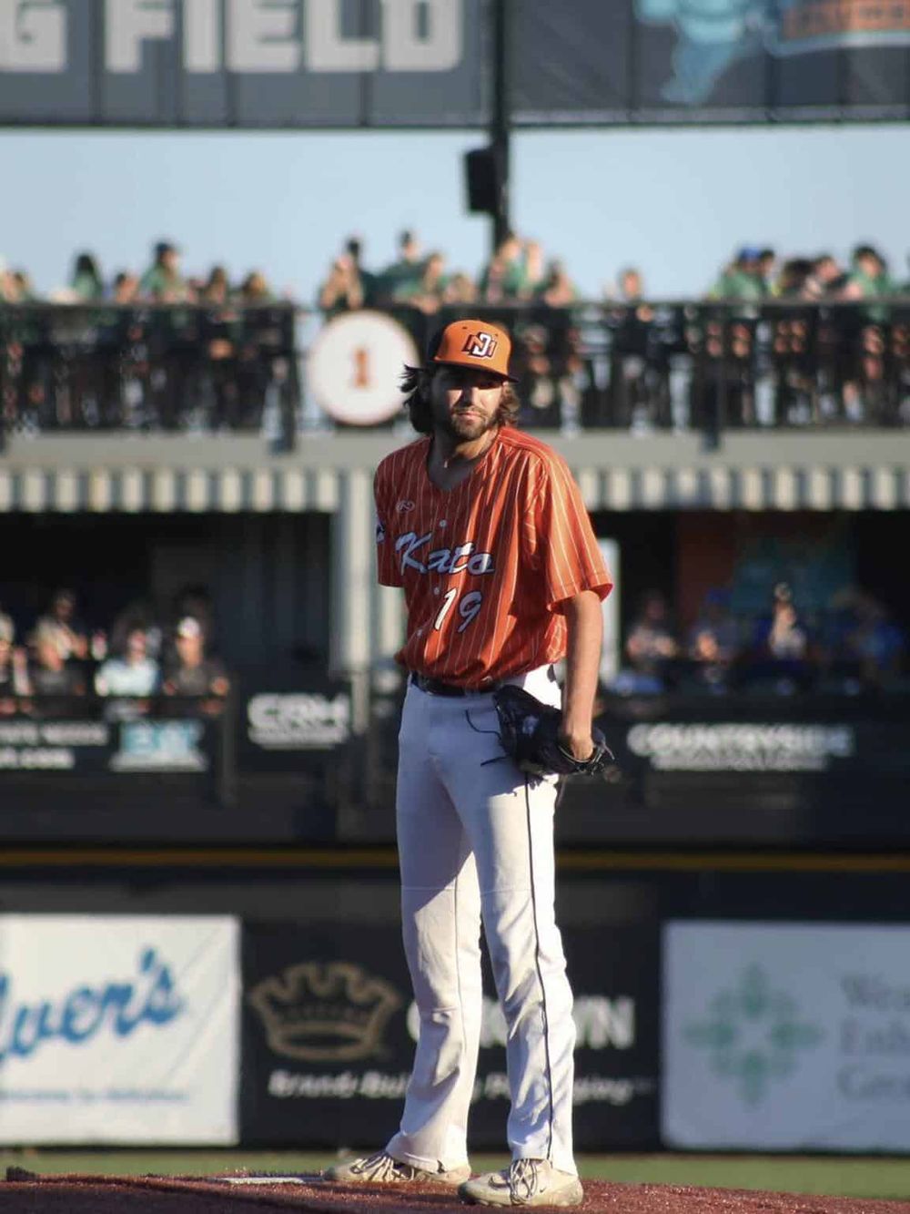 Baseball player standing on the field during a game, focused and ready to play.