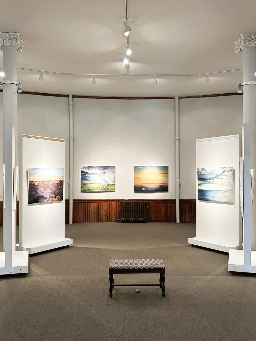 Colorful landscape photos displayed at an art gallery or photography exhibit inside QuestForDirections.