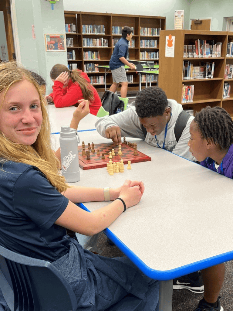 1. Children playing chess in a school library for educational activities.