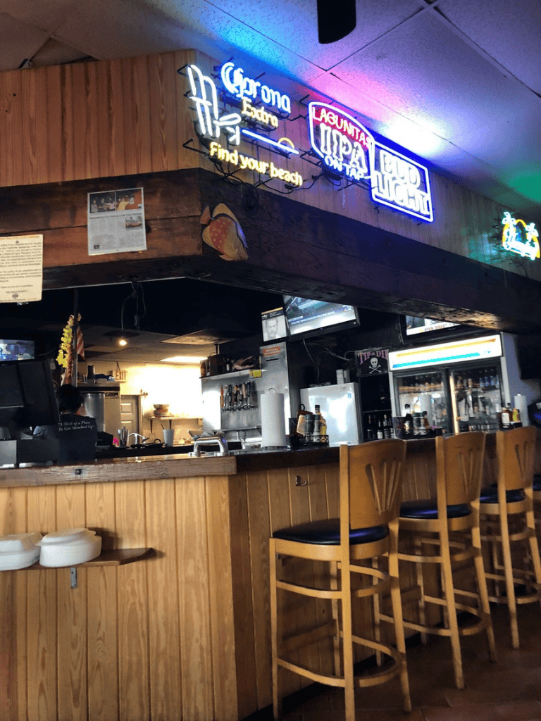 Neon bar signs at a beachside restaurant.