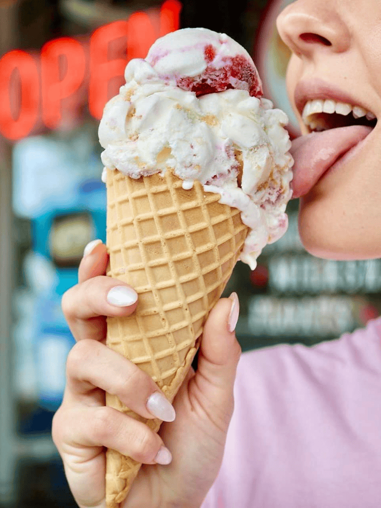 Delicious ice cream cone with strawberry and vanilla flavors, enjoying a sweet treat on a sunny day.