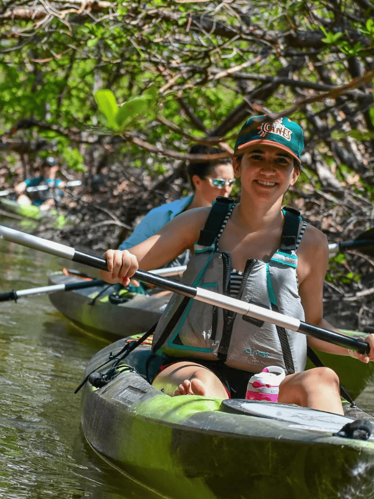 Kayaking adventure through lush mangrove tunnels for eco-tourism.