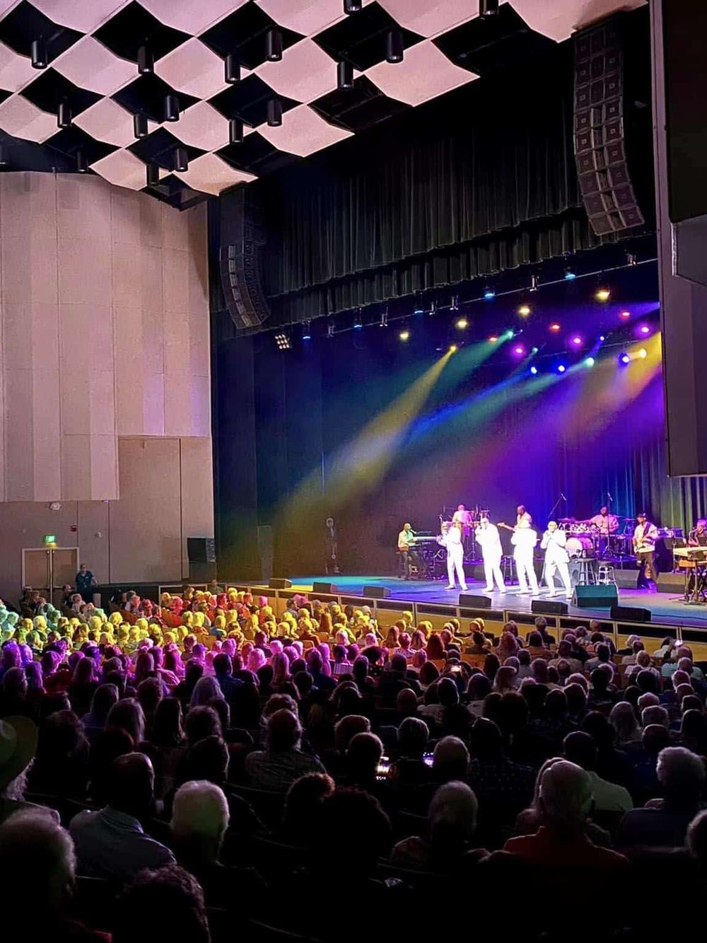 Colorful concert stage with singing performers and audience at QuestForDirections venue.